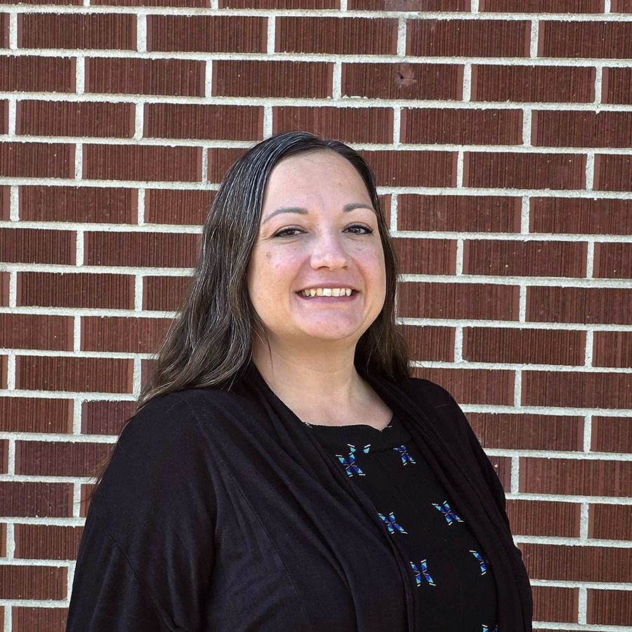 Kristy Colima standing in front of a brick wall